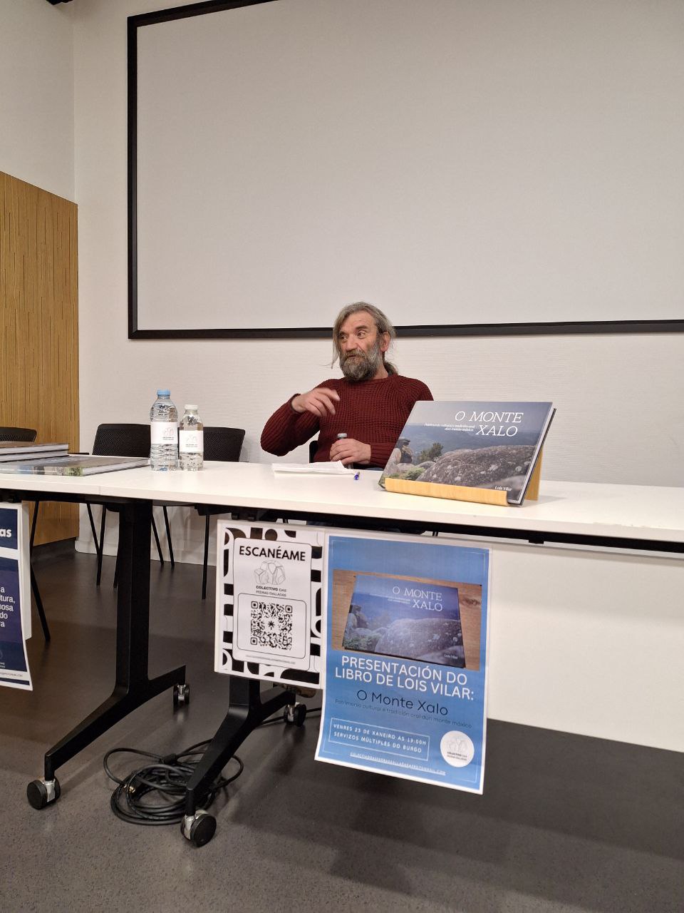 Lois Vilar na mesa falando do monte Xalo cos seus libros e cartaces